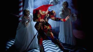 Spectacle musical nommé "Fantasio" réalisé par la troupe de L’Éternel Été à l'espace des Augustins Un homme déguisé en joker de carnaval avec un micro à la main tenant la pose