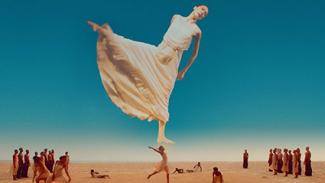 Projection du film "Dancing Pina" à l'espace des Augustins Femme portant une robe blanche et réalisant un mouvement de danse dans les airs