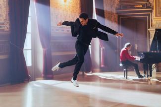 Tap Virtuoso Un danseur de claquette saute. Un pianiste joue dans le fond